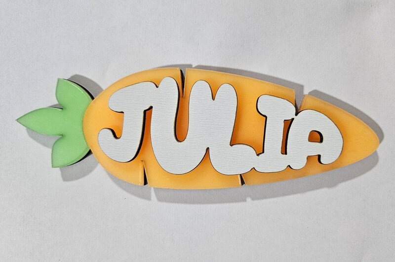 Layered carrot name tag reading 'Julia' made with orange and green acrylic